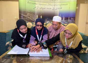 ZAWIAH (dua dari kiri) bersama Mohd. Isa serta Siti Salehah (kiri) dan Faizah Suaida meneliti al-Quran bertulisan Braille di Abraj Al Janadriyah, Mekah semalam.