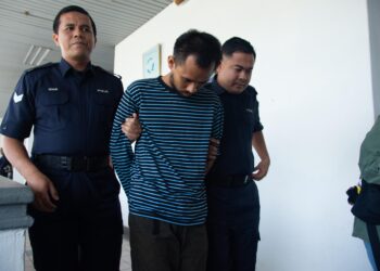 MALKAN Maha diiringi anggota polis ketika dihadapkan ke Mahkamah Sesyen, Ayer Keroh, Melaka. 