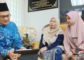 MOHD. HAPIZI Mohamad Ali bersama dua bekas anak muridnya yang kini menjadi rakan bertugas sebagai guru di SMKA Dato’ Haji Abu Hassan Haji Sail. –  UTUSAN/NOR AINNA HAMZAH
