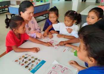 NORIAH Pandak (dua dari kiri) mengajar subjek sains kepada murid Orang Asli dengan bantuan gambar 
di SK Sungai Kiol, Jerantut, Pahang. – UTUSAN/HARIS FADILAH AHMAD