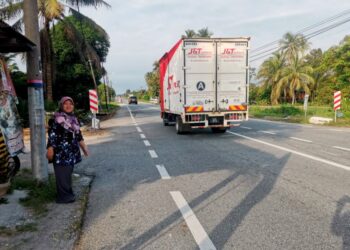 SARINAH Hasan menunjukkan Jalan Sungai Manik-Sungai Lampam yang lurus, laluan berlakunya kemalangan yang mengorbankan sembilan anggota FRU, kelmarin.