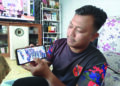 KOPERAL Nizam Tarmizi menunjukkan gambar kenangan rakan-rakannya ketika ditugaskan membuat kawalan di Teluk Intan Selasa lalu. – UTUSAN