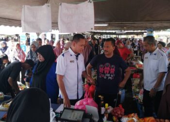 MOHD. Musfi Lat  meninjau  Program Jualan Rahmah Madani (PJRM)   luar premis terbuka sempena Hari Pekerja di Dataran Kuala Berang, Hulu Terengganu. - UTUSAN/ NOOR HAYATI MAMAT