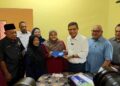 SAIFUDDIN Nasution Ismail menyampaikan MyKad kepada Nurul Arini pada Program Ziarah dan Meraikan Pelajar Cemerlang SPM di Kampung Bukit Tembok, Pasir Panjang, di sini, hari ini. UTUSAN/NOR AINNA HAMZAH