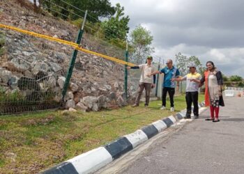 BEBERAPA penduduk menunjukkan runtuhan cerun yang menyebabkan kerosakan pada pagar kediaman di Rini Homes 7, Iskandar Puteri, Johor.