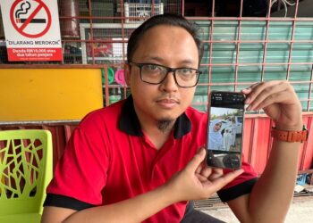 MUHAMMAD Syahrul Ikhwan Seri Buana menunjukkan gambar isterinya yang disimbah asid dalam kejadian di Beris Kubur Besar, Bachok, Kelantan.