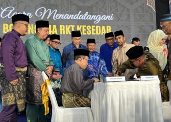 AHMAD Zahid Hamidi (tengah) menyaksikan proses menandatangani dokumen rasmi bagi urusan pindah milik tanah pada Majlis Penyerahan Bantuan Program Perumahan Rakyat Sejahtera (PPRS) dan Majlis Hari Raya Aidilfitri Kesedar 2025 di Dataran Awam Kampung Jerek, Gua Musang, Kelantan. – UTUSAN/AIMUNI TUAN LAH