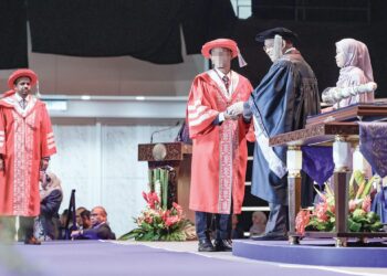 Dr. Murad ketika menerima skrol Ijazah Doktor Falsafah (PHD) daripada Pro-Canselor Open University Malaysia (OUM), Tan Sri Azman Hashim pada majlis konvokesyen universiti itu di Pusat Dagangan Dunia Kuala Lumpur, semalam. – MINGGUAN/SYAKIR RADIN