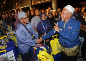 DAUD Che Ngah bersalaman dengan jemaah kumpulan pertama haji Andalusia KT011B yang akan berangkat ke Tanah Suci di Kompleks TH Sepang. - UTUSAN/FAISOL MUSTAFA