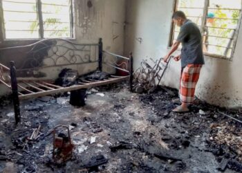 CHE Mazlan Abdul Hamid melihat keadaan rumahnya yang hangus di Kampung Kubang Edang, Peringat, Kota Bharu, Kelantan. - UTUSAN/ ROHANA MOHD.NAWI