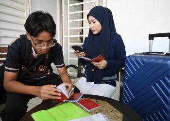 Rakyat Malaysia, Hasmira Hashim, 41, bersama anaknya membuat semakan akhir pada TDAC yang diisi secara dalam talian tiga hari sebelum memulakan percutian ke Hatyai, Thailand. – UTUSAN/IZLIZAN OTHMAN
