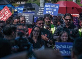 WAKIL pengamal perubatan berhimpun di hadapan Pejabat Perdana Menteri (PMO) bagi membantah pelaksanaan peraturan yang mewajibkan klinik swasta dan farmasi mempamerkan harga ubat-ubatan. - UTUSAN/FAIZ ALIF ZUBIR