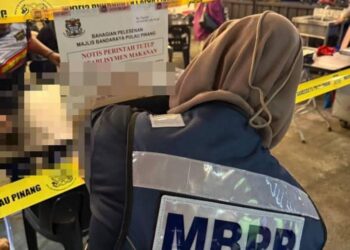 SEORANG anggota penguatkuasa MBPP melekatkan notis penutupan selama 14 hari ke atas sebuah premis makanan dalam daerah Timur Laut di George Town, Pulau Pinang