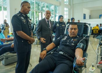 MOHAMED Usuf (kiri) ketika melihat anggota polis, Mohd Kamarulzaman menderma darah pada Program Derma Darah Sempena Hari Polis ke-218 di IPK Kuala Lumpur di sini, hari ini. Gambar ISKANDAR ISHAK