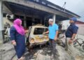 FARIDAH Mohamed (kiri) melihat keadaan kereta Perodua Kancil yang digunakan untuk menjual sate yang rosak dalam kejadian kebakaran awal di Jalan Surian 7, Taman Desaru Utama, Bandar Penawar, Kota Tinggi.