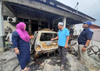 FARIDAH Mohamed (kiri) melihat keadaan kereta Perodua Kancil yang digunakan untuk menjual sate yang rosak dalam kejadian kebakaran awal di Jalan Surian 7, Taman Desaru Utama, Bandar Penawar, Kota Tinggi.