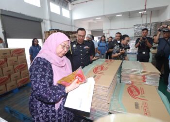 FUZIAH Salleh melihat proses pembungkusan minyak paket semasa lawatan ke sebuah syarikat pembungkusan minyak di Jalan Kempas Lama, Johor Bahru.
