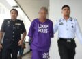 PEMANDU lori pembancuh simen berusia 49 tahun diiringi anggota polis selepas dibawa ke Mahkamah Majistret, Ayer Keroh, Melaka untuk permohonan reman. - UTUSAN/AMRAN ALI