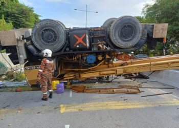 SEBUAH kren pembinaan tergelincir sebelum terbalik dan melintangi jalan berhampiran SMK Bayan Lepas di Pulau Pinang.-GAMBAR/JBPM PULAU PINANG