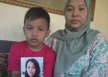 SITI Rahman Othman bersama Muhammad Jeffri menunjukkan gambar Latifah yang sedang dicari mereka bagi tujuan permohonan Sijil Pengangkatan JKM.-UTUSAN/NOR SHAFIQAH MOHD GHAZALI