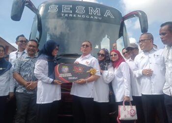 MOHD. Zuber Embong (lima dari kiri) menyerahkan replika kunci bas kepada Hayati A Rahman di SESMA, Kuala Terengganu, hari ini. - UTUSAN/ZAID MOHD.NOOR