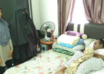 RAHIMAH B. Karim (tengah) melihat salah seorang anaknya yang berstatus OKU terlantar di kediaman Rumah Transit Asnaf MAINJ di PPR Sungai Tiram, Johor Bahru, Johor.