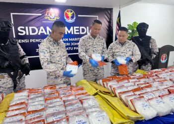 KAMA Azri Kamil (tengah) menunjukkan sebahagian dadah dipercayai jenis methamphetamine yang dirampas di perairan Sungai Ayam, Batu Pahat.