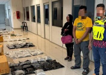 ANGGOTA polis bersama dua suspek yang ditahan semasa sedang memunggah dadah dalam serbuan di pangkalan haram Tok Awang Belulang di Rantau Panjang, Kelantan-IHSAN PGA.