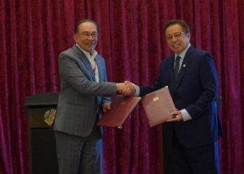 ANWAR Ibrahim bersama Premier Sarawak, Tan Sri Abang Johari Tun Openg bertukar perjanjian persefahaman (MoU) pada Majlis Pertukaran Memorandum Persefahaman Kerajaan Persekutuan dengan Kerajaan Sarawak di Bangunan Perdana Putra, Putrajaya, hari ini. - UTUSAN/FAISOL MUSTAFA