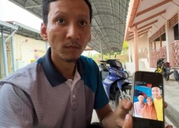 HAFIZAH MOHAMAD menunjukkan gambar bapa dan ibu saudaranya Mazalan Balia dan isterinya Radin Pauziyah Radin Ahmad yang meninggal dunia selepas terlibat dalam kemalangan di Jalan Bindu - Tongkang Pechah, pagi semalam.