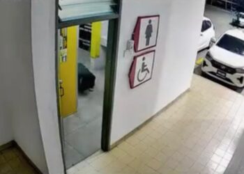 TANGKAP layar yang diambil daripada satu rakaman video menunjukkan seorang lelaki (berbaju hitam) sanggup merangkak semata-mata untuk mengintai dari bahagian bawah pintu tandas wanita di sebuah stesen minyak di Seberang Jaya, Pulau Pinang.-GAMBAR/MEDIA SOSIAL