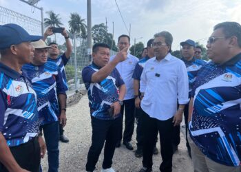 JOHARI Abdul Ghani mendengar penerangan daripada wakil penduduk, Zaidi Japar (tiga dari kiri) ketika meninjau projek pembangunan di Kampung Parit Bilal dan Kampung Parit Ahmad bersempena dengan Majlis Penyerahan Kampung Angkat Madani di Dewan Serbaguna Taman Melodi, Batu Pahat, Johor.