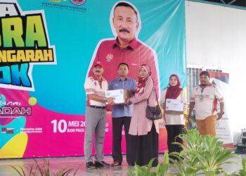 RUSLIN Jusoh (kiri) ketika menyampaikan hadiah pada Program Sua Mesra Bersama Ketua Pengarah AADK di Kampung Gong Kemunting, Besut, Terengganu. - UTUSAN / WAN ZURATIKAH IFFAH WAN ZULKIFLI