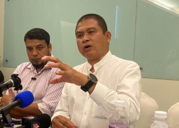 MUHAMMAD Rafique Rashid Ali menunjukkan dua laporan polis yang dibuat oleh saksi berkenaan dalam sidang akhbar di WP Hotel, Kuala Lumpur. - UTUSAN/ARIF AIMAN ASROL