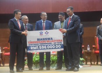 AHMAD Samsuri Mokhtar (tengah) menyaksikan penyerahan Mock Cheque Biasiswa Terengganu Sejahtera antara Pengarah Yayasan Terengganu, Ahmad Farhan Abdul Wahab (kanan) kepada Rektor UC TATI, Prof. Ir. Dr Hairul Azhar Abdul Rashid sempena Hari Terbuka Universiti College TATI di Kemaman, Terengganu. - UTUSAN/NIK NUR IZZATUL HAZWANI NIK ADNAN