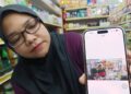 NURASYIKIN Ishak menunjukkan gambar lelaki yang terakam dalam CCTV yang melarikan sebanyak 15 kampit beras dan satu pukal gula dalam kejadian di Rembau Central, Rembau, semalam. UTUSAN/NOR AINNA HAMZAH