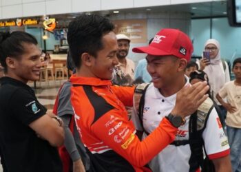 Zulfahmi Khairuddin (tengah) menyambut kepulangan Hakim Danish Ramli di Lapangan Terbang Antarabangsa Kuala Lumpur, Sepang, semalam. - IHSAN SIC RACING