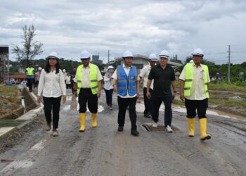 AHMAD Maslan (berbaju biru) ketika meninjau salah satu projek seliaan JKR di Kota Kinabalu semalam.