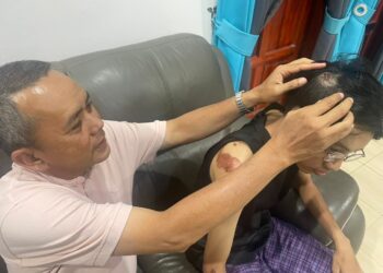 MOHD Affandi Ab. Ghani (kiri) menunjukkan kecederaan yang dialami anaknya di kepala dan beberapa bahagian badan selepas terjatuh dari motosikal akibat serangan kera liar di Kampung Batu Lada, Kuala Krai, Kelantan. - UTUSAN/ROSMIZAN RESDI