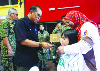 Mohamed Khaled Nordin menyerahkan sumbangan kepada keluarga anggota tentera sempena Majlis Ramah Mesra Warga Kem Kabota, Tawau, kelmarin.