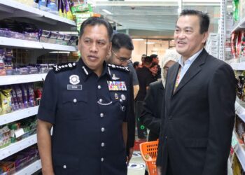 hai Kee Kan (kanan) beramah mesra dengan Rusdi Md. Isa ketika lawatan Ketua Polis Kuala Lumpur ke KK Mart, baru-baru ini.