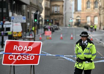 Seorang anggota polis berkawal di jalan raya Liverpool selepas insiden sebuah kereta merempuh orang ramai yang sedang meraikan kemenangan pasukan The Reds, kelmarin. - AFP