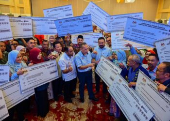 MOHD. Asri Abdul Wahab (tengah) beramah mesra bersama penerima bantuan pada Program Hal Ehwal Kesatuan Sekerja (PHEKS) 2025 Peringkat Zon Timur di Hotel Raia, Kuala Nerus, Terengganu hari ini. - UTUSAN/PUQTRA HAIRRY