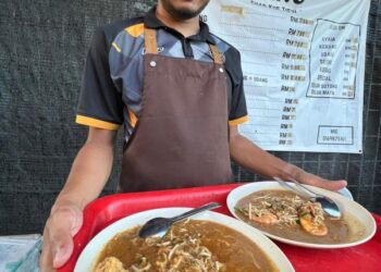 HILMI Ahmad bersama dulang hidangan di Restoran Chaw Kuey Tiaw di Pasir Puteh, Kelantan.