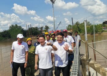 NGA Kor Ming (depan) meninjau projek pembangunan fizikal dan sosial di Kampung Bahagia di Teluk Intan hari ini. - UTUSAN/AIN SAFRE BIDIN