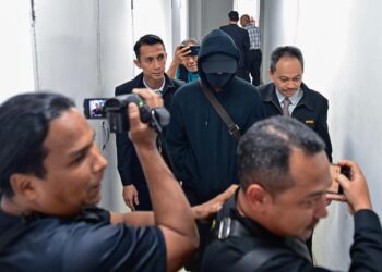SEORANG pegawai polis berpangkat inspektor yang dituduh menerima rasuah dibawa keluar dari Mahkamah Sesyen Kuala Terengganu. - UTUSAN/PUQTRA HAIRRY ROSLI
