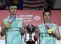 Aaron Chia dan Soh Wooi Yik bersama hadiah kemenangan  menjuarai Kejohanan Badminton Terbuka Thailand di Bangkok, semalam. - AFP