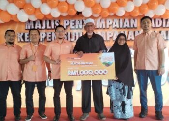 Yaacob Ishak (tengah) bersama cek RM1 juta yang dimenanginya selepas diumum sebagai Pemenang Jutawan Sijil Simpanan Islamik (SSi) Bank Muamalat di Kampung Raja, Besut, Terengganu.