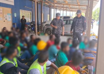 MOHD. Yusri Mohd. Nor (berdiri, dua dari kanan) ketika memeriksa pekerja asing di sebuah tapak pembinaan bangunan di Bandar Baru Kijal, Kemaman, Terengganu. -UTUSAN/NIK NUR IZZATUL HAZWANI NIK ADNAN