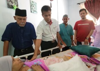 DR. Zaini Hussin (kanan) meluangkan masa melakukan pemeriksaan kesihatan terhadap salah seorang pesakit terlantar semasa program Ziarah Kasih di KRT Bukit Gading, Tanah Merah, Kelantan. - UTUSAN/MUSTAQIM MOHAMED